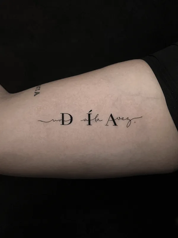 Tatuaje minimalista 1 dia a la vez realizado por Clayton Goethe